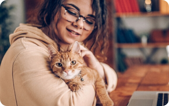 A woman holds a cat in her arms